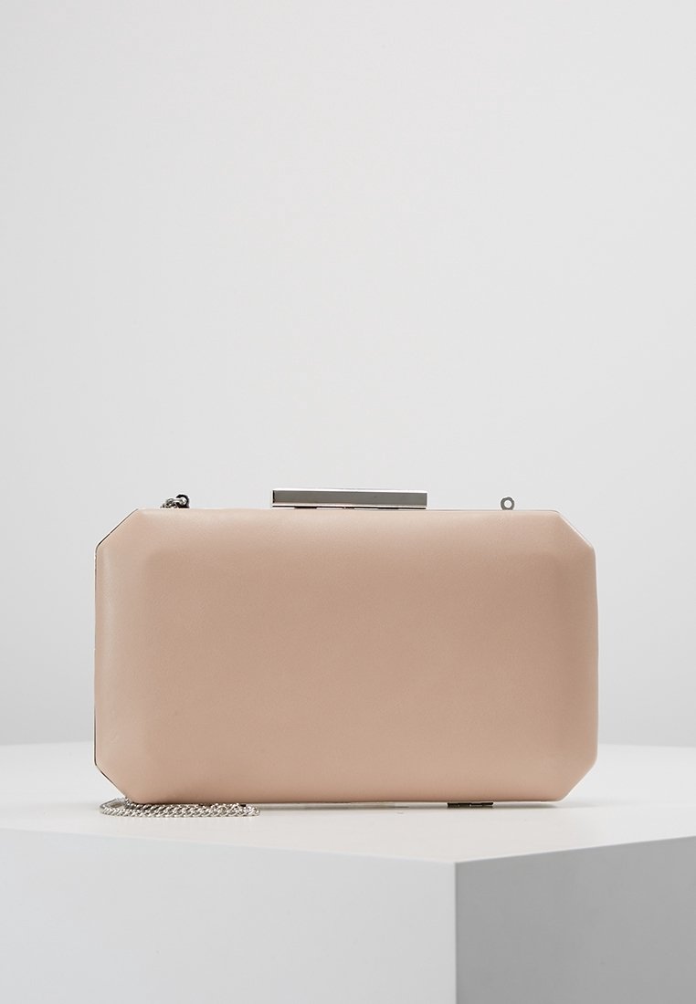 Beige rektangulär clutchväska med rundade hörn, silverfärgad metallspänne och kedjearm hållande på en vit yta.