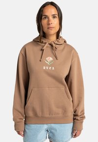 Brun hoodie med känguruficka, justerbar dragsko på huven och blommig logotyp. Mjuk tyg, avslappnad passform, ribbade ärmslut och fåll.