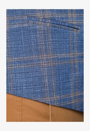 Niebieska tkanina w kratkę o teksturowanej powierzchni, zawierająca ciemne i jasne nici. Zawiera boczną kieszeń, połączoną z jasnobeżowym materiałem poniżej.