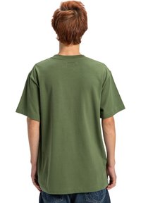 Zelené bavlněné tričko s krátkým rukávem a uvolněným střihem. Obsahuje jednoduchý design bez viditelných vzorů nebo akcentů na zadní straně.