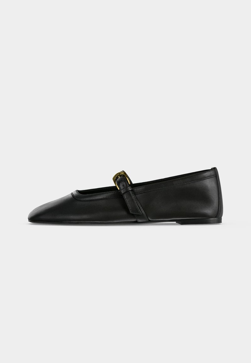 Black leather Mary Jane flat shoe with a pointed toe and a thin strap featuring a small gold buckle, shown from the side on a plain background.