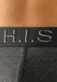 Men's underwear with a black elastic waistband featuring embossed gray letters "H.I.S." on a dark gray fabric, smooth texture.