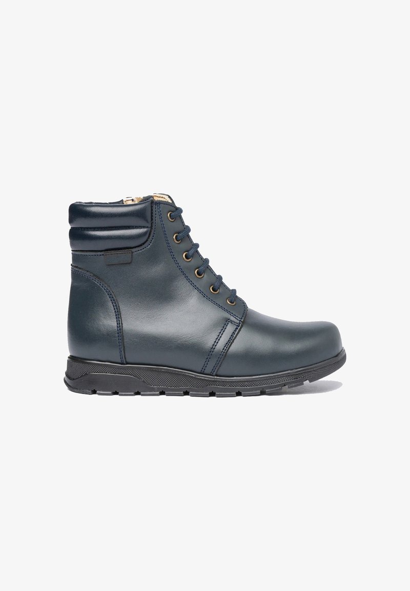 Bota de tobillo de cuero azul marino con cuello acolchado, cierre delantero con cordones, suela de goma negra y cremallera lateral forrada con piel beige.