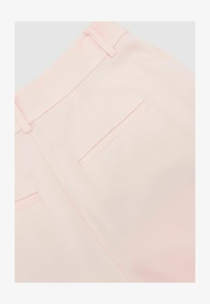 Hellrosa Hose mit Gürtelschlaufen und zwei waagerechten Paspeltaschen auf der Rückseite, im Nahaufnahme-Detail gezeigt.