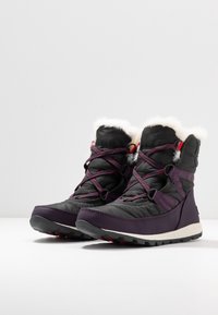 Schwarze und lila isolierte Stiefel mit einem Kunstpelzkragen, gepolstertem Design, kontrastierenden Schnürsenkeln und einer strukturierten Sohle für besseren Halt.
