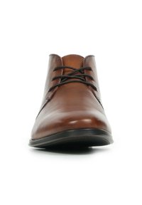 Zapato de piel marrón con un acabado suave, punta redondeada y cordones negros. Textura sutil semi-mate, diseñado con una suela baja negra.