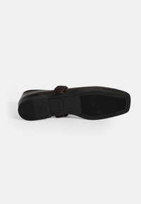 Schwarze Ledersohle mit strukturierten Gummigrip-Mustern. Verfügt über ein glattes Design und eine leichte Krümmung an der Ferse. Keine sichtbaren Beschläge.