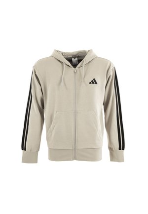 Sudadera beige con cremallera hecha de algodón suave. Cuenta con capucha, dos bolsillos frontales y rayas verticales negras en contraste en las mangas.