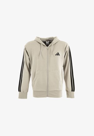 Beige Kapuzenjacke mit Reißverschluss aus weicher Baumwolle. Verfügt über eine Kapuze, zwei Fronttaschen und kontrastierende schwarze vertikale Streifen an den Ärmeln.