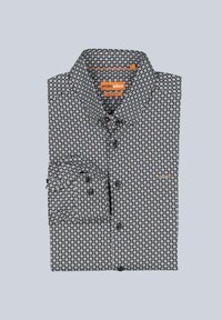 Schwarz-weiß gemustertes Hemd mit Knopfleiste und klassischem Kragen, mit kreisförmigen Designs, einer linken Brusttasche und orangefarbenen Akzenten.