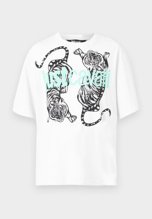 Λευκό κοντομάνικο μπλουζάκι με δύο μαύρους και άσπρους τίγρεις και γαλάζιο κείμενο "Just Cavalli" μπροστά.