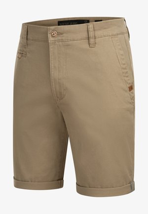 Beige színű pamut rövidnadrág, felgörbített szegéllyel, gombos záródással és oldalsó zsebekkel. A zsebre kis márkás címke van varrva.