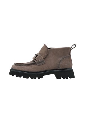 Brown suede ankle boot with black chunky rubber sole and decorative strap with metal buckle on the side.