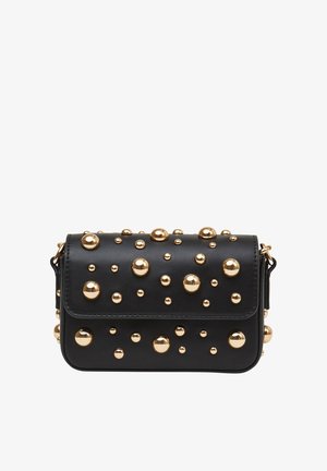 Sac à main en cuir noir avec des clous en métal doré. Forme rectangulaire, fermeture à rabat et une bandoulière amovible. Surface texturée avec des accents audacieux.