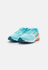 Zapatillas de correr turquesas con una parte superior de malla transpirable, acentos blancos, acabado textil texturizado y una amortiguación de talón en naranja contrastante.