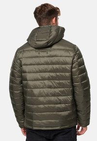 Oliven grøn pufferjakke med en aftagelig hætte, quiltet design og en glat tekstur. Har et logo-patch på ærmet.