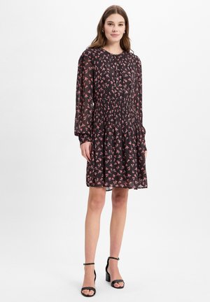 Schwarzes Blumenkleid mit langen Ärmeln, gerafftem Bund und fließendem Rock. Verziert mit rosa Blumen, aus leichtem Stoff und mit rundem Ausschnitt.
