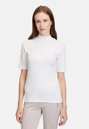 T-shirt col roulé blanc à manches courtes, en tissu lisse et léger. Design ajusté avec une silhouette épurée et un minimum de détails.