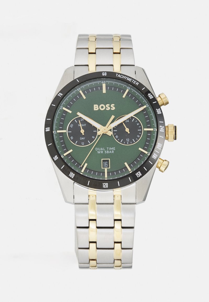 Orologio dual-time con quadrante verde, cinturino in acciaio inossidabile oro e argento, lunetta tachimetrica nera e sub-quadranti cronografici. Resistente all'acqua fino a 5 bar.