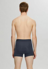 Tummansinisen väriset bokserit, jotka istuvat tiukasti. Niissä on pehmeä vyötärönauha, jossa on "SELECTED"-merkintä, sekä sileä, texturoitu kangas.