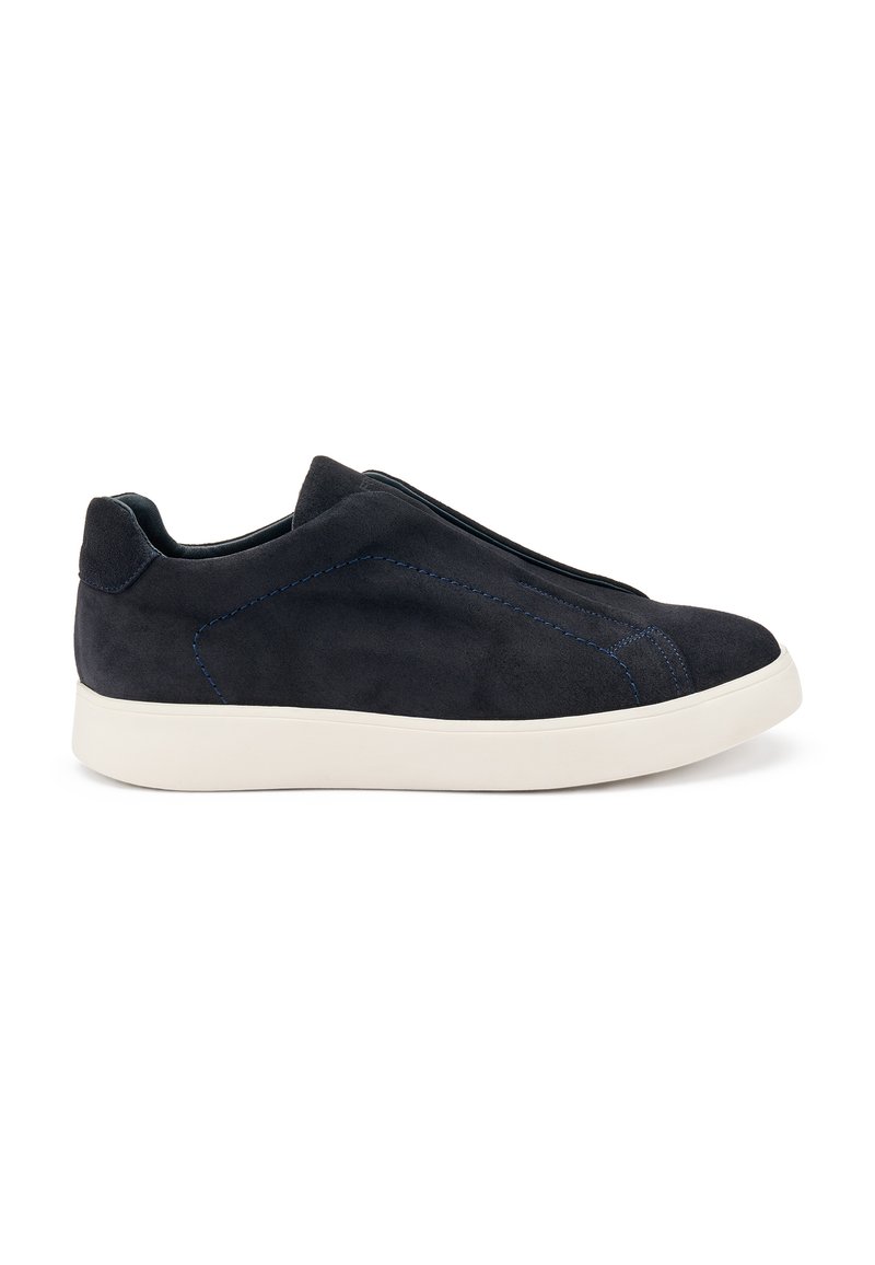 Zapatillas de ante negro tipo slip-on con suela de goma blanca, que presentan costuras azules y un diseño aerodinámico. Sin cordones visibles.