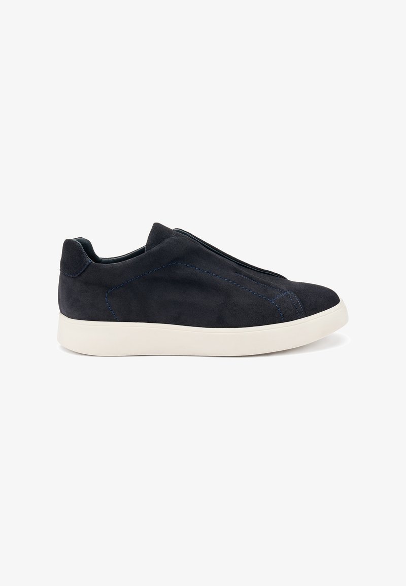 Zapatillas de ante negro tipo slip-on con suela de goma blanca, que presentan costuras azules y un diseño aerodinámico. Sin cordones visibles.