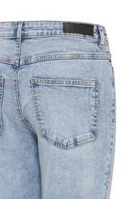 Jeans de denim azul claro con una textura suave, que cuentan con dos bolsillos traseros y una etiqueta de marca negra en la cintura.