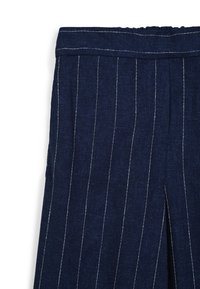 Tissu bleu marine à rayures fines avec une texture douce et une taille élastique, featuring des coutures blanches subtiles le long des lignes verticales.