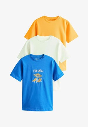 Három rövid ujjú, kerek nyakú póló narancssárga, fehér és kék színekben, a kék pólón "Club Soleil" felirat és strand szék grafika található.