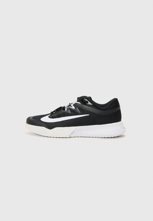 Chaussure de sport noire et blanche au design élégant, semelle blanche et grand logo blanc sur le côté, vue de l'extérieur.