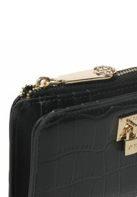 Clutch de piel negra con textura de cocodrilo, que cuenta con un cierre y herrajes dorados, y un acento metálico decorativo en el cierre.