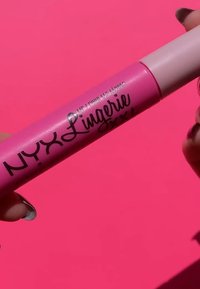 Rosa flytande läppstift i en cylindrisk behållare med en glansig finish. Har fet svart text och en mjuk, rund applikator.