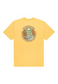 Žluté bavlněné tričko s grafickým designem hor, slunce a vody, s textem "Quiksilver" a sloganem uspořádaným do kruhu na zadní straně.