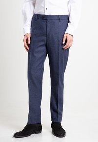 Blaue Wollmischung-Anzughose mit Slim-Fit, flachem Vorderteil und G�ürtelschlaufen, kombiniert mit schwarzen Wildleder-Stiefeletten.
