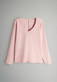 Svijetlo ružičasti longsleeve V-izrez gornji dio izrađen od mekane tkanine, s opuštenim krojem i bočnim prorezima na rubu za dodatnu pokretljivost.