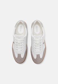 Sneakers bianchi con accenti in suede grigio, punta rotonda e suola piatta in gomma. Presentano un design perforato e lacci bianchi. Logo sulla linguetta.