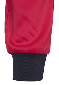 Rode sportpant met een manchet dat is voorzien van een zwarte ribbel-elastische band. De stof lijkt lichtgewicht en glad met zichtbare stiksels.