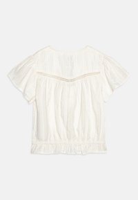 White cotton blouse with short sleeves, textured fabric, gathered hem, and decorative stitching along the back yoke.