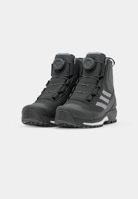 Czarne buty trekkingowe z syntetyczną cholewką, teksturowanym wykończeniem, dwoma pokrętłami BOA do sznurowania oraz wytrzymałymi gumowymi podeszwami z wzorami zapewniającymi przyczepność.