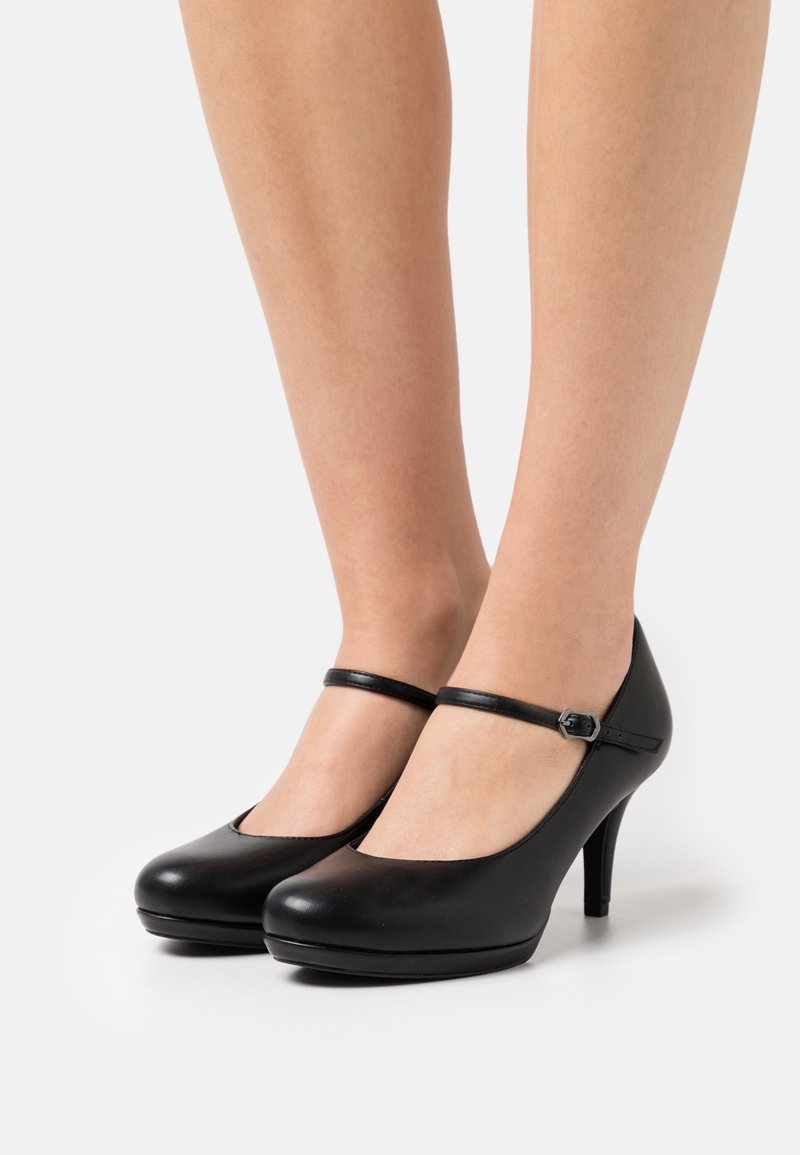 Svarta läder Mary Jane-klackar med rund tå, ankelrem och en 10 cm hög stilettklack. Slät yta och subtil lyster.