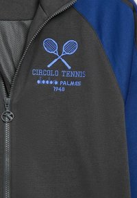 Giacca zip grigia scura con dettagli blu, presenta ricami di racchette da tennis, testo "Circolo Tennis" e una trama di tessuto liscia.