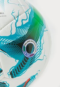 Hvid fodbold med livlige blå og grønne grafiske designelementer. Har sorte accenter og et cirkulært logo med teksten "PALLONE UFFICIALE SERIE A 2025/2026."