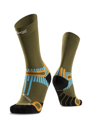 Een paar olijfgroene sportsokken met blauwe en oranje geometrische patronen en zwarte versterkte tenen en hielen.