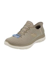 Beige athletic shoe with a textured mesh upper, rounded toe, and light-colored sole. Features laces and logo accent on the side.