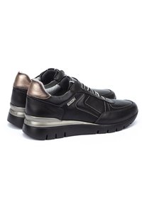 Schwarze Ledersneaker mit einem metallisch bronze-farbenen Fersenelement, strukturierten Schnürsenkeln und einer gepolsterten Sohle mit Rillen für besseren Halt.