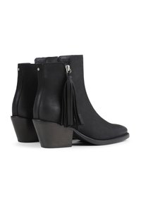 Botas negras hasta el tobillo hechas de cuero con punta afilada, un tacón medio y un fleco decorativo en el lateral. Textura suave con costuras detalladas.