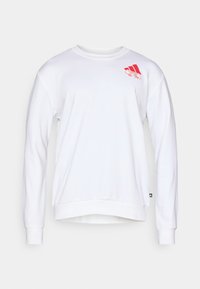 Bílá mikina z měkké tkaniny, s kulatým výstřihem, dlouhými rukávy a červeným logem v levém horním rohu. Jednoduchý, čistý design.