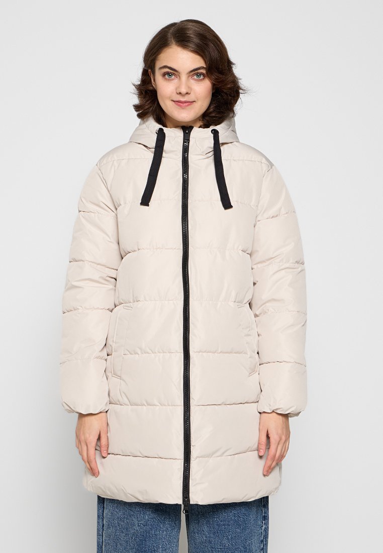 Abrigo tipo puffer en beige claro, con cremallera negra y capucha con cordón. Diseño acolchado con mangas largas y bolsillos laterales.
