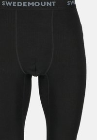 Sorte leggings med ribbet tekstur, der har en sort talje med "SWEDEMOUNT" i grå, som giver en tætsiddende pasform.
