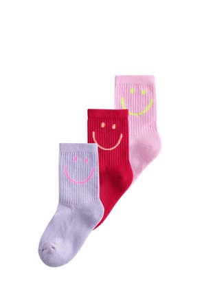 Three colorful ribbed socks in purple, red, and pink, each with a large smiley face design on the ankle area.